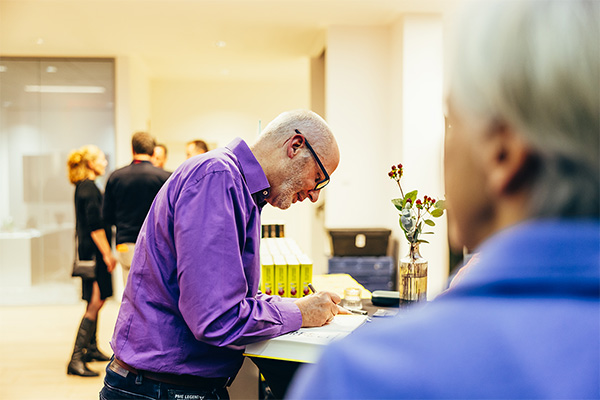 Autor Peter Grandl signiert ein Buch.