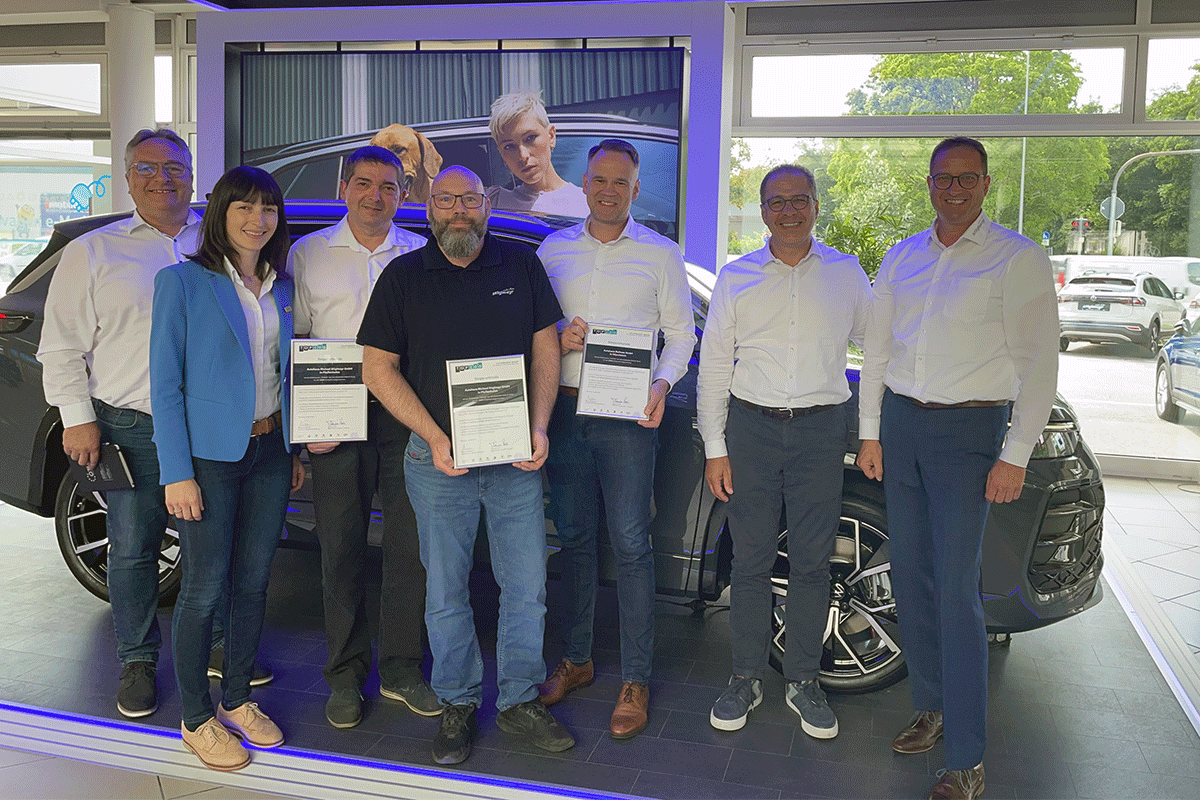 Teiledienstleiter Andreas Rossol, NORA-Experte Klaus Priller und NORA-Kundenbetreuer Martin Lechner stehen mit der Auszeichnung von einem NORA Aufsteller.